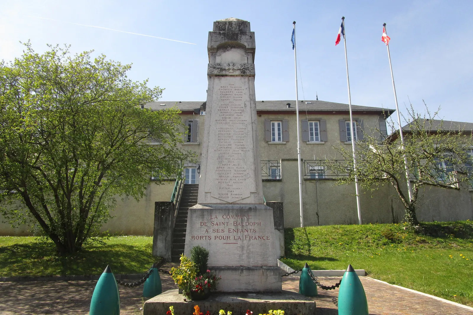 Trois mâts derrière le monument aux morts de Saint-Baldoph