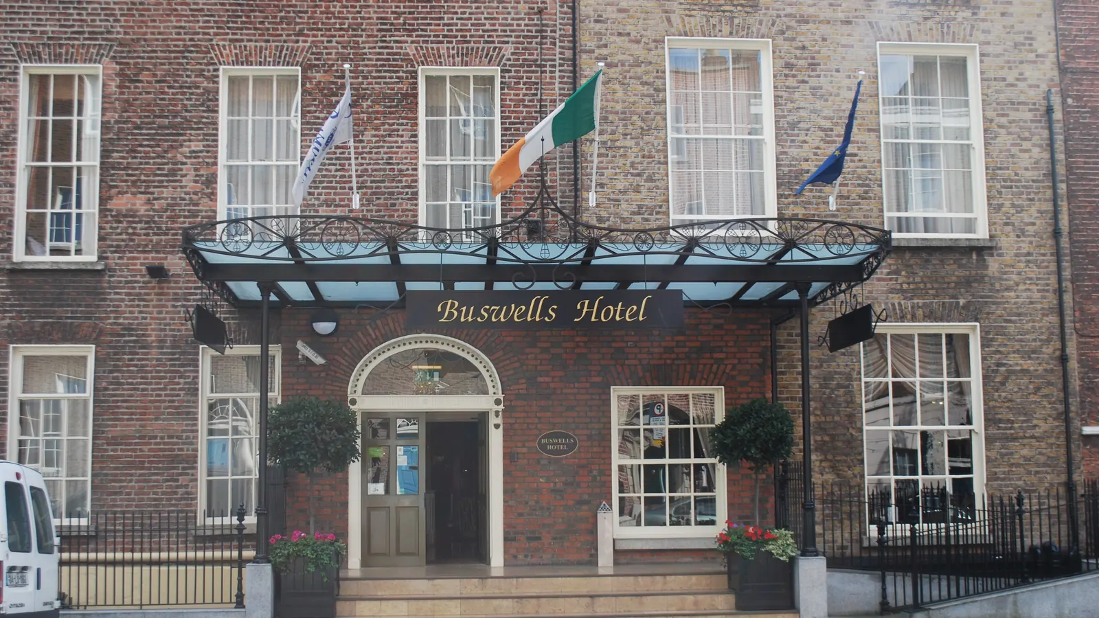 Buswells Hotel in Dublin with flags on wall-mounted poles