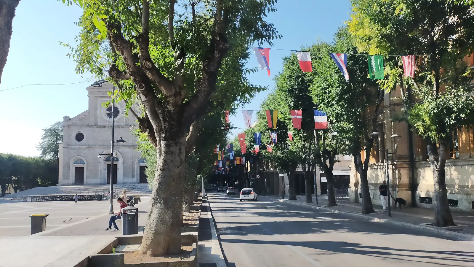 Bandierine di vari Paesi appese agli alberi lungo una strada di piazza Risorgimento