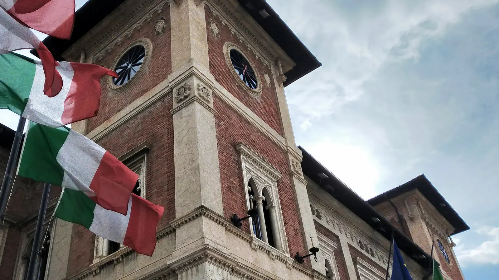 Il palazzo municipale di Avezzano con numerose bandiere tricolori esposte sulla facciata