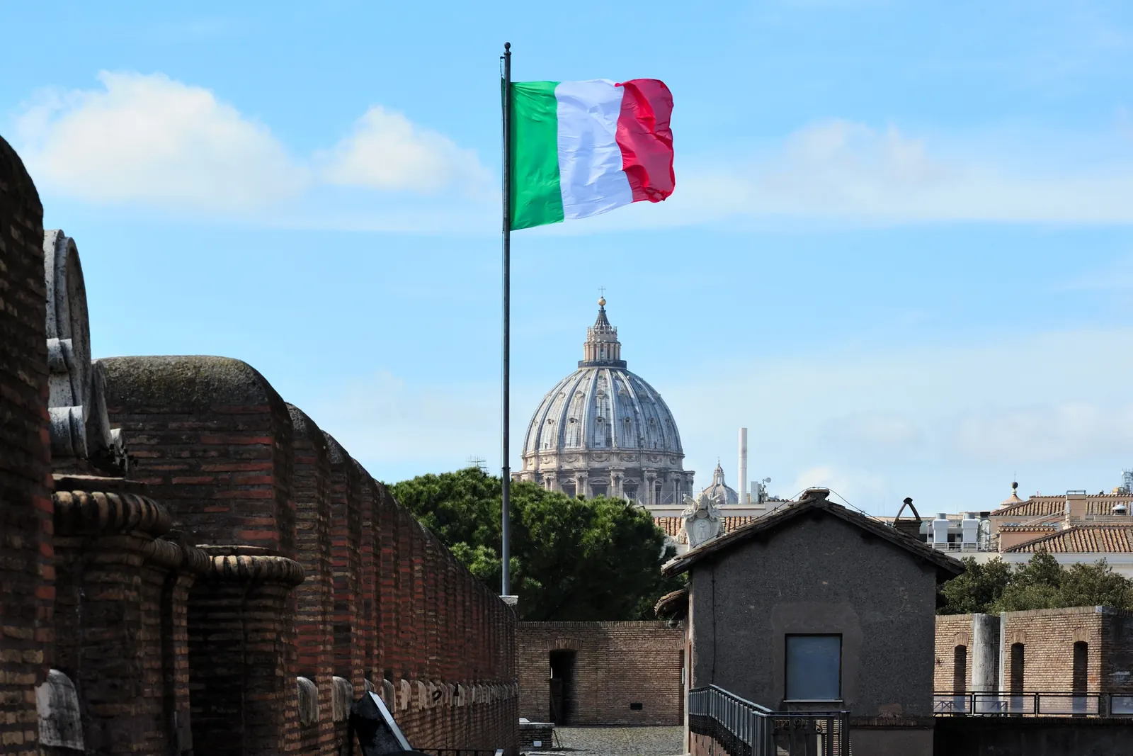 Il Tricolore su un pennone di Castel Sant'Angelo, con la cupola di San Pietro sullo sfondo