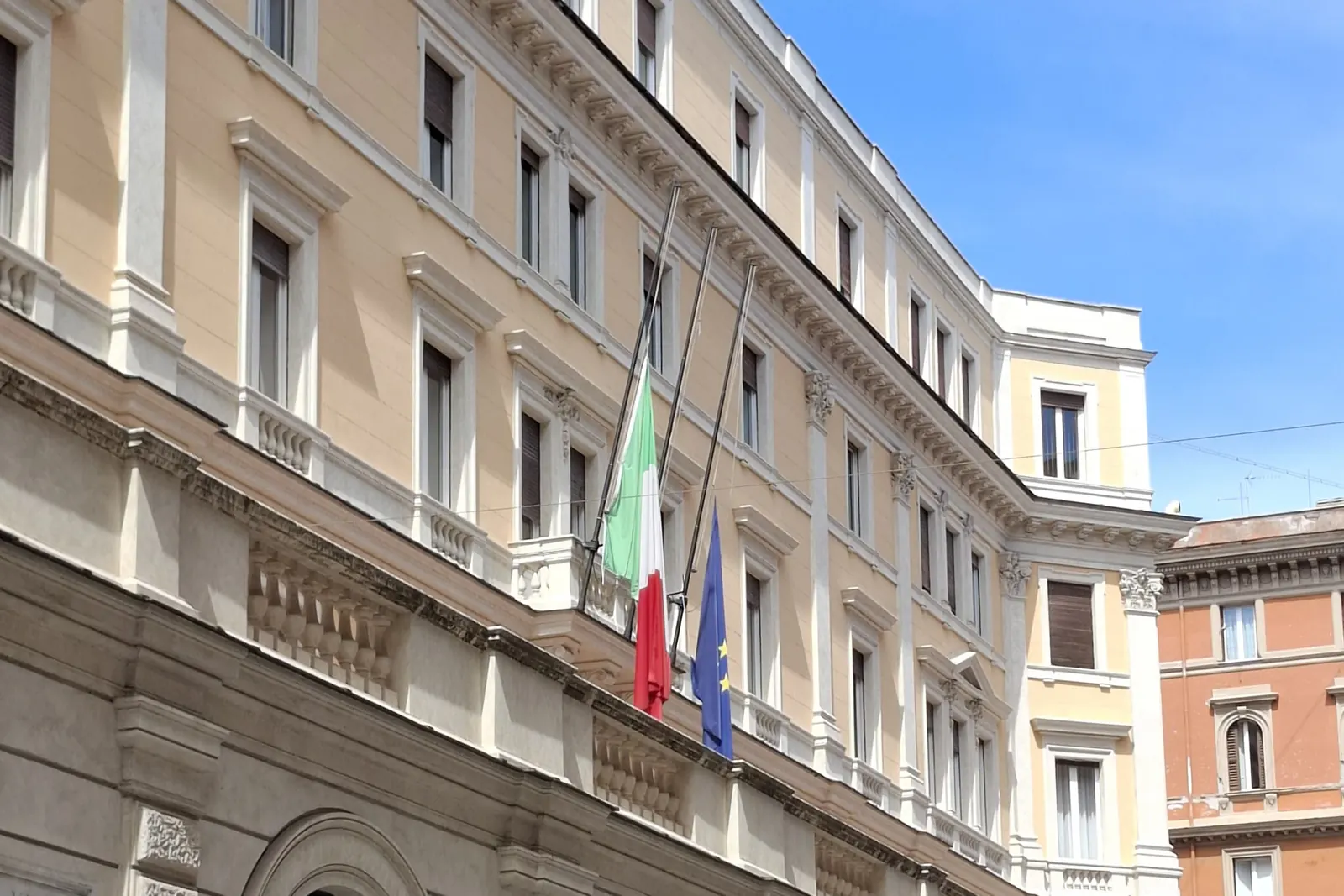 Il Tricolore e la bandiera europea a mezz'asta sulla facciata di un palazzo pubblico dopo la morte di papa Francesco
