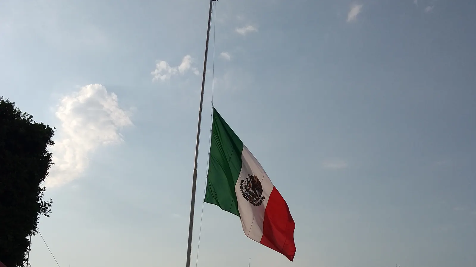 La Bandera Nacional a media asta en una plaza al atardecer