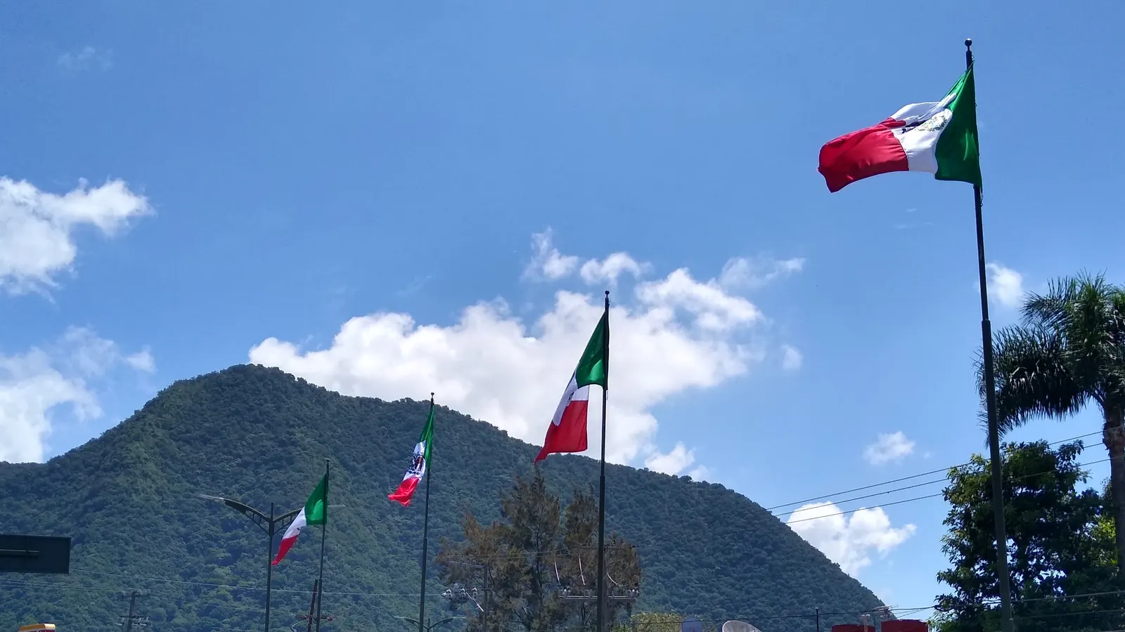 Banderas de México en postes a lo largo del Boulevard Circunvalación de Orizaba, Veracruz, con el cerro al fondo