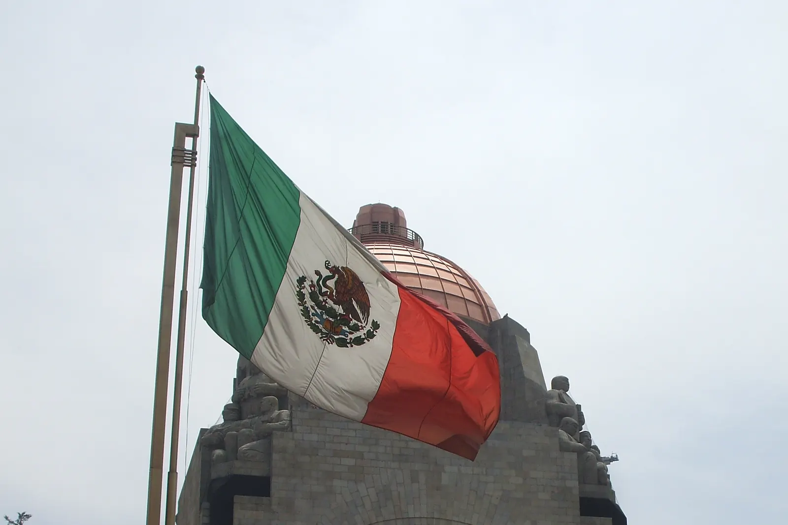 La Bandera Nacional en un asta frente al Monumento a la Revolución en la Ciudad de México