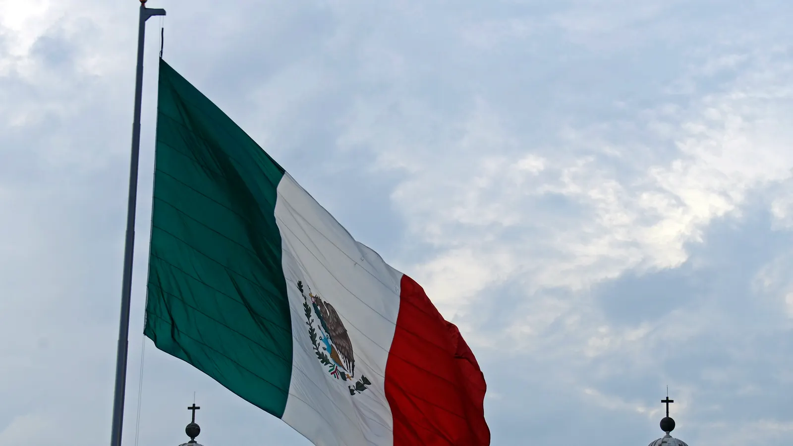 La bandera monumental ondea sobre el Zócalo de la Ciudad de México, entre las torres de la Catedral