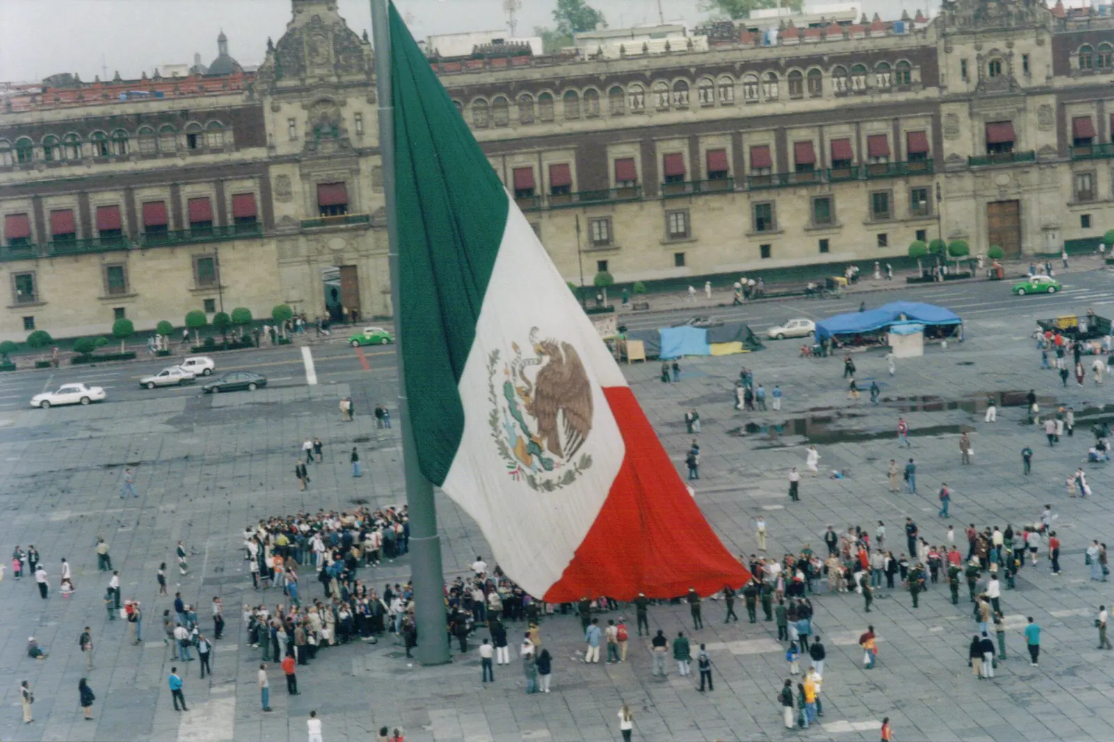 Izamiento de la bandera monumental en el Zócalo, con el público alrededor del asta