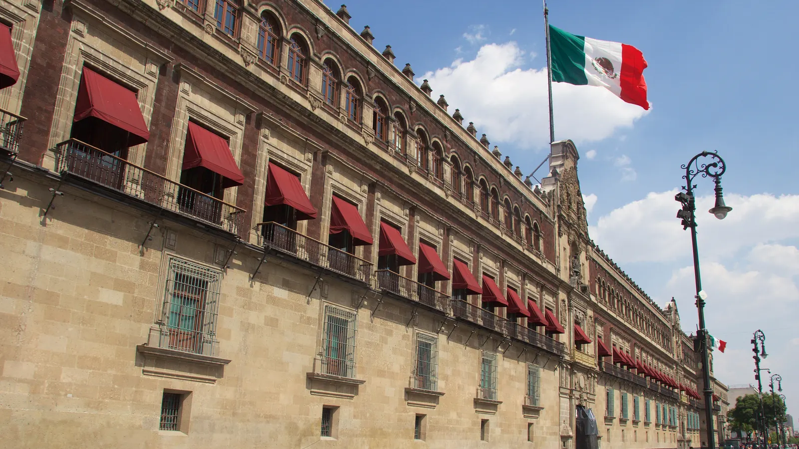 La fachada del Palacio Nacional en la Ciudad de México con la Bandera Nacional en el asta del techo