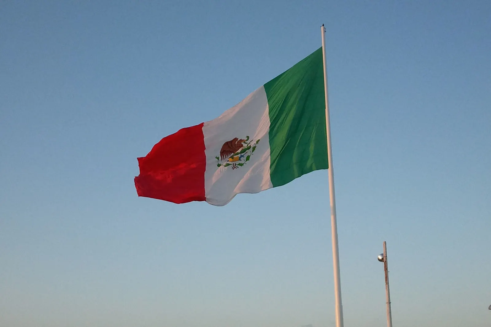 La bandera monumental de Cozumel en su asta junto al mar