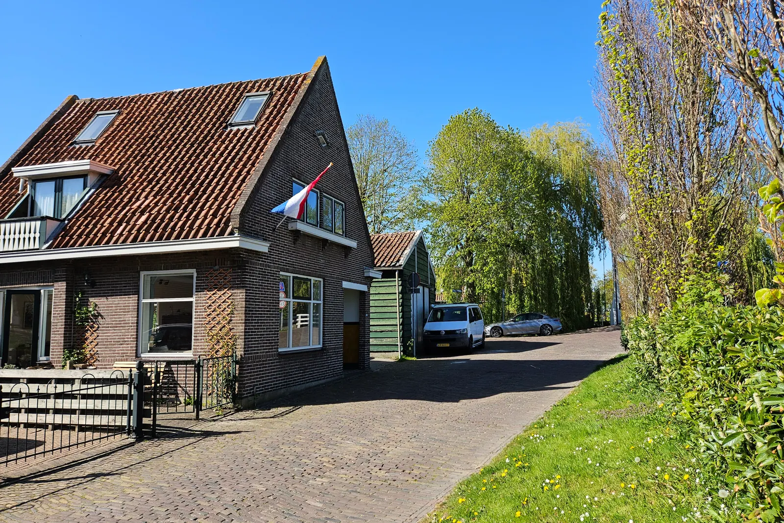 Bakstenen huis aan de Oosterkade in Edam met de Nederlandse vlag aan een stok aan de gevel