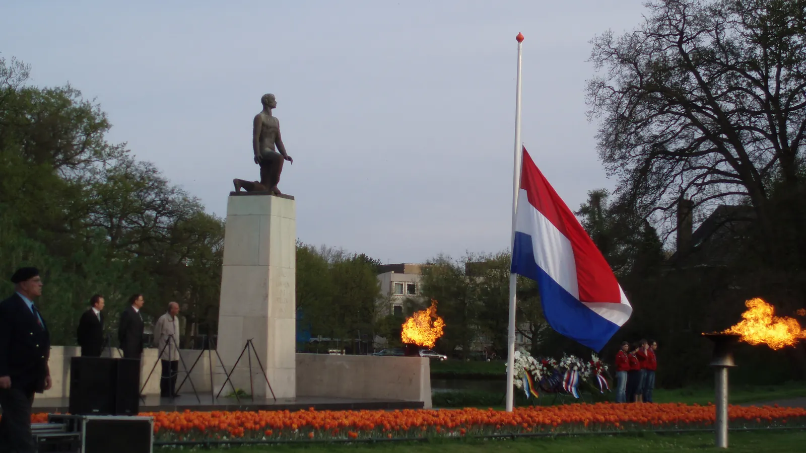 Herdenking bij het oorlogsmonument in Zwolle met de vlag halfstok en brandende fakkels