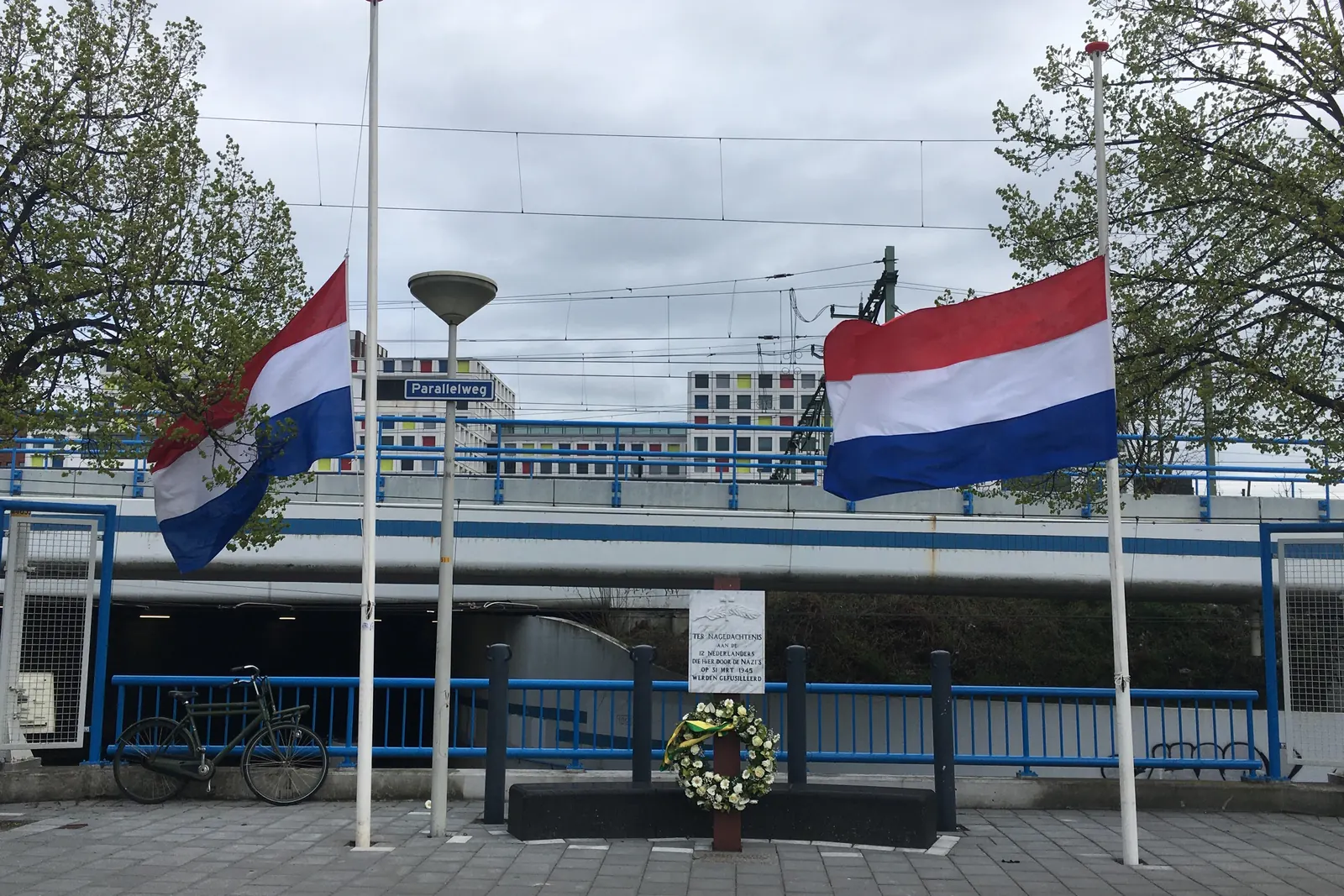 Monument aan de Parallelweg in Den Haag met een krans en twee vlaggen halfstok