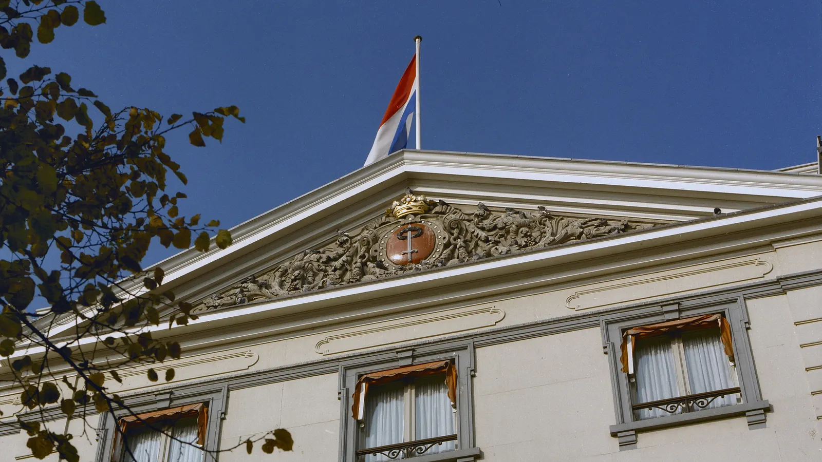 Het fronton van Hotel Des Indes in Den Haag met de Nederlandse vlag