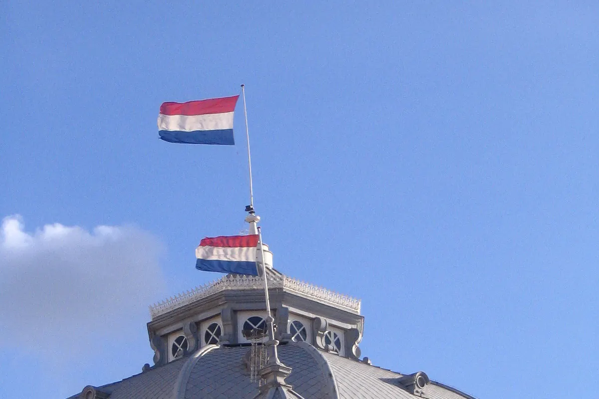 Het Kurhaus in Scheveningen met Nederlandse vlaggen aan masten op het dak en de koepel