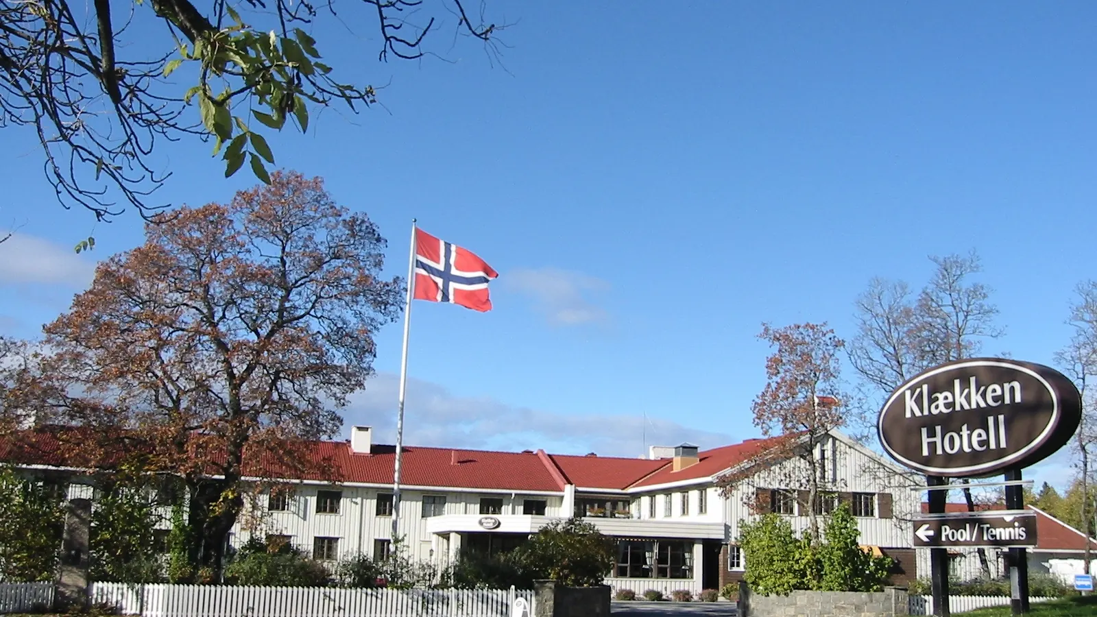 Klækken hotell på Ringerike med norsk flagg på en høy flaggstang