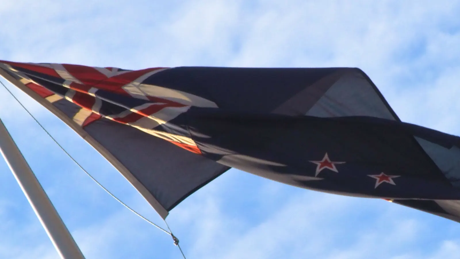 The New Zealand flag stretched out in a strong wind