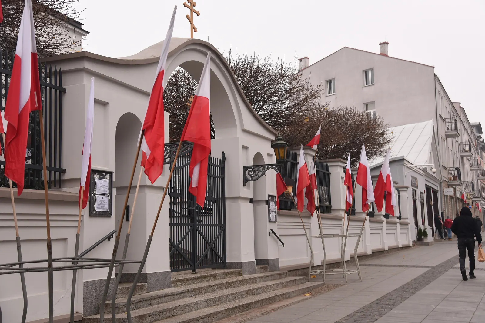 Biało-czerwone flagi przy ogrodzeniu kościoła w Białymstoku w Narodowe Święto Niepodległości