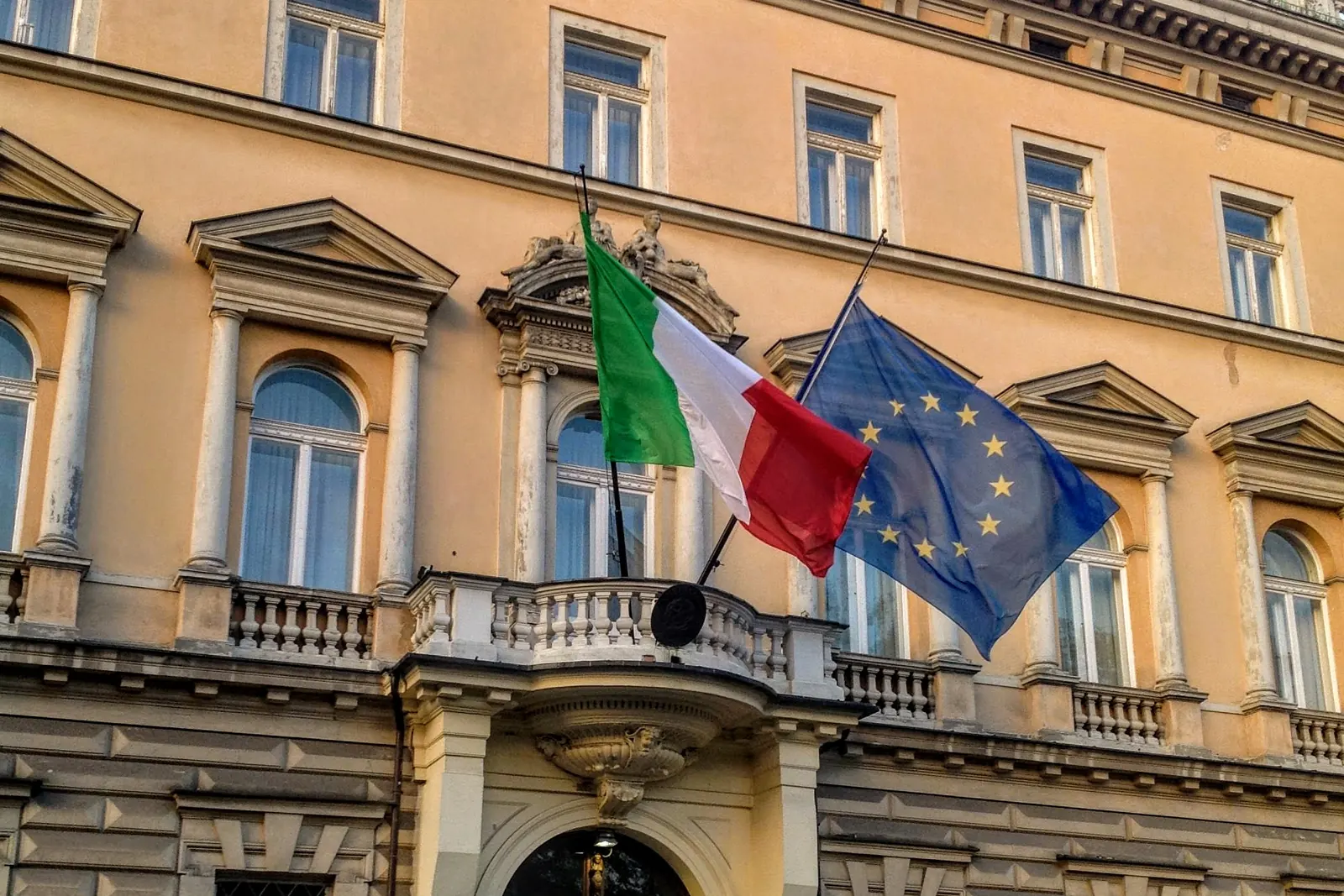 Flagi Włoch i Unii Europejskiej na fasadzie Pałacu Szlenkierów w Warszawie