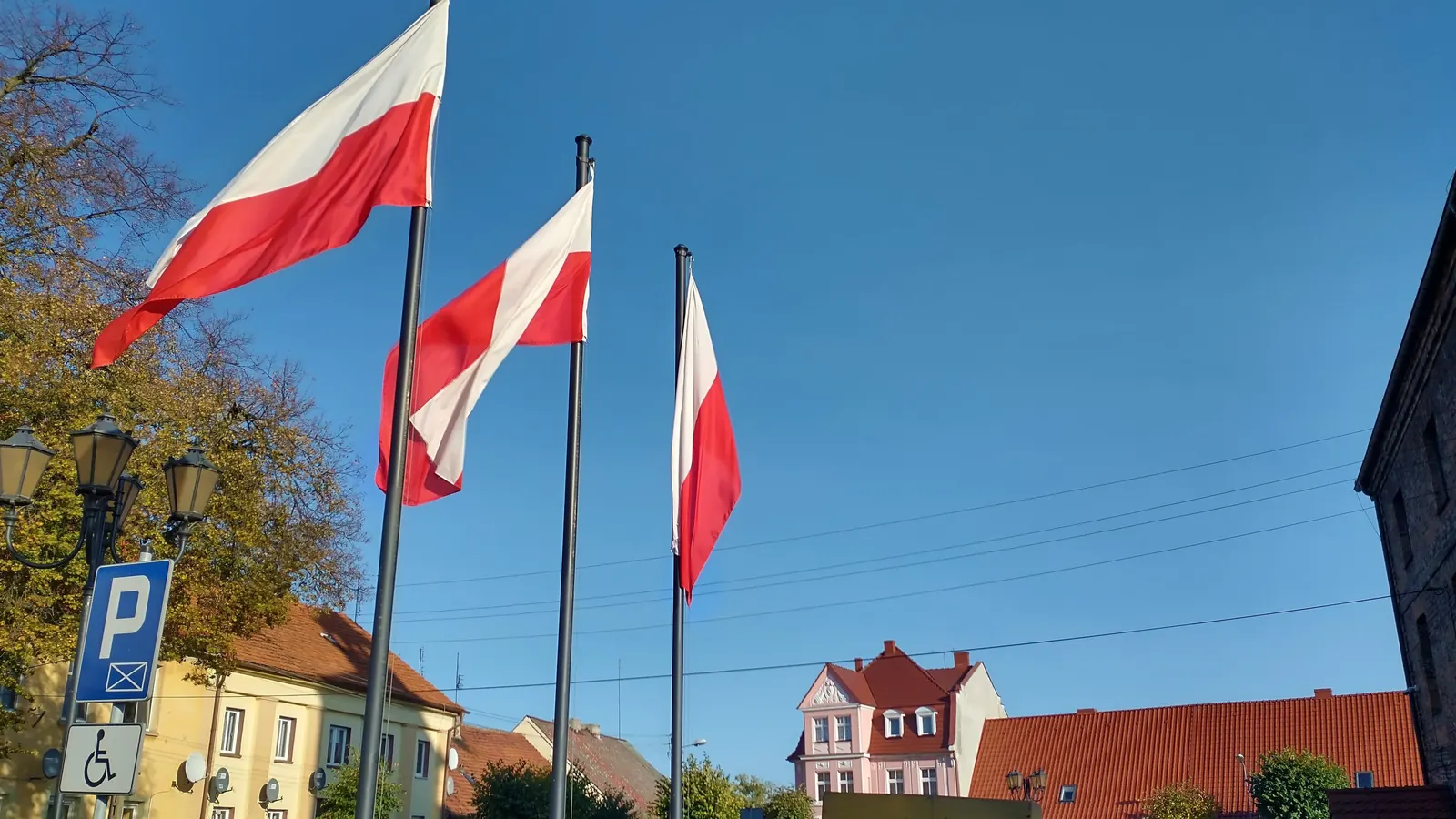 Trzy maszty flagowe na rynku w Obrzycku