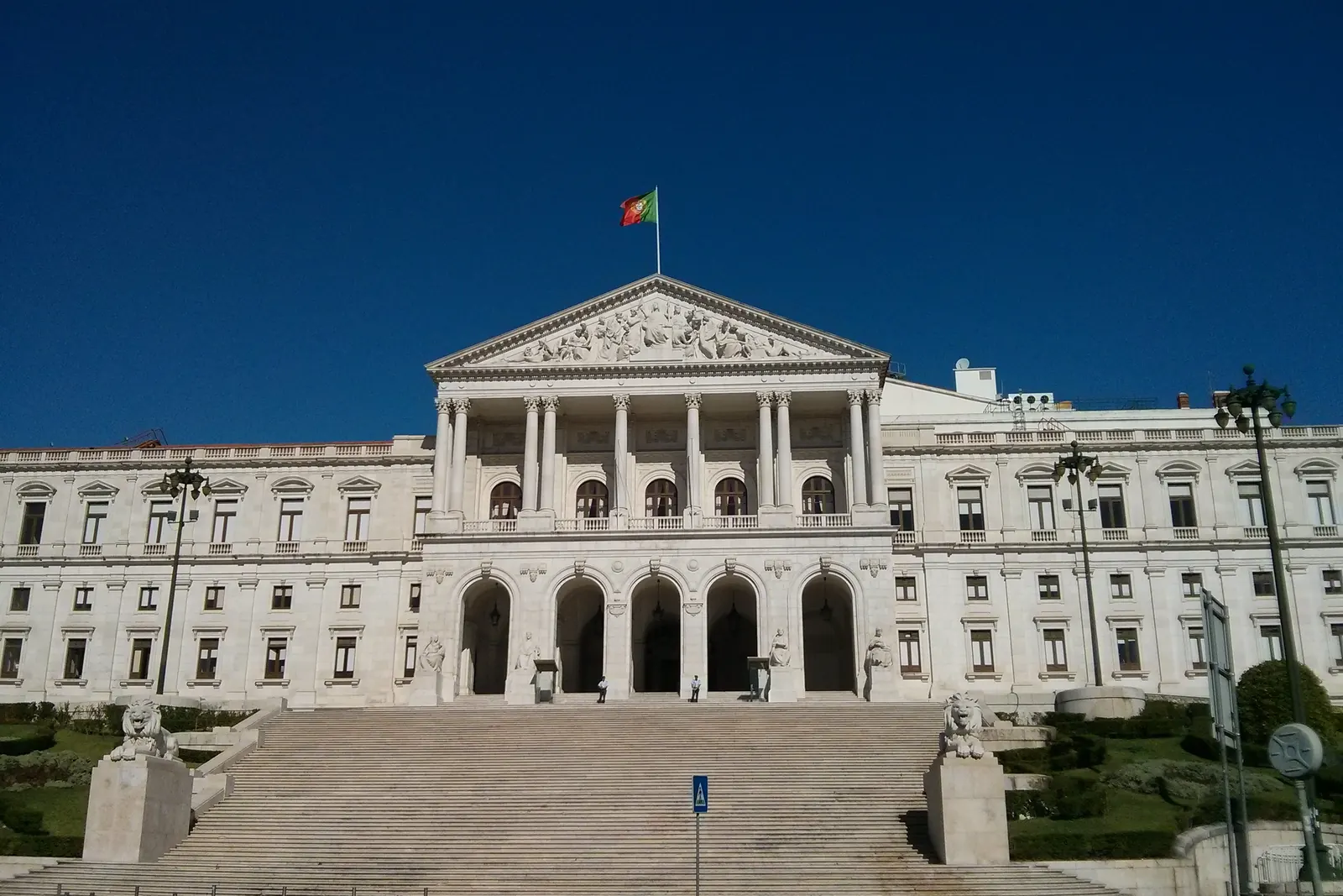 O Palácio de São Bento, sede da Assembleia da República, com a Bandeira Nacional no mastro do frontão