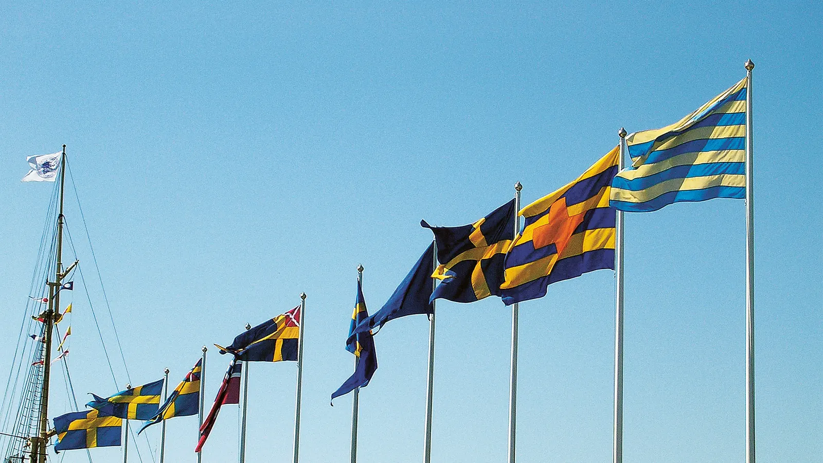 Rad av flaggstänger med historiska svenska flaggor vid Sjöhistoriska museet i Stockholm