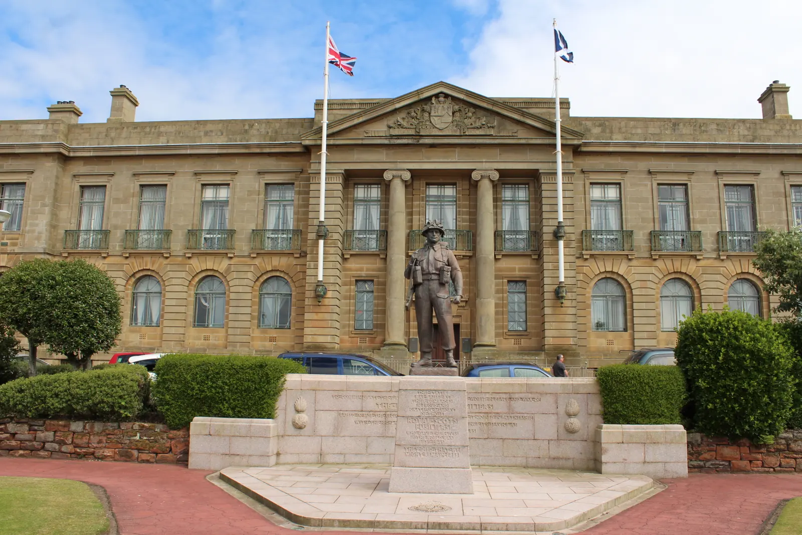The Union Flag and the Saltire on two flagpoles behind the war memorial in front of the County Buildings in Ayr
