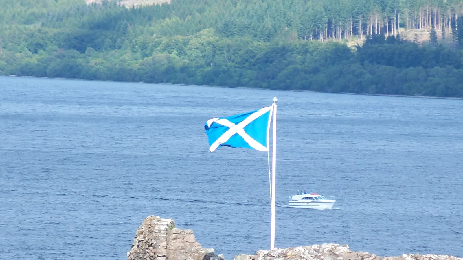 The Saltire on a flagpole by the ruins of Urquhart Castle on Loch Ness