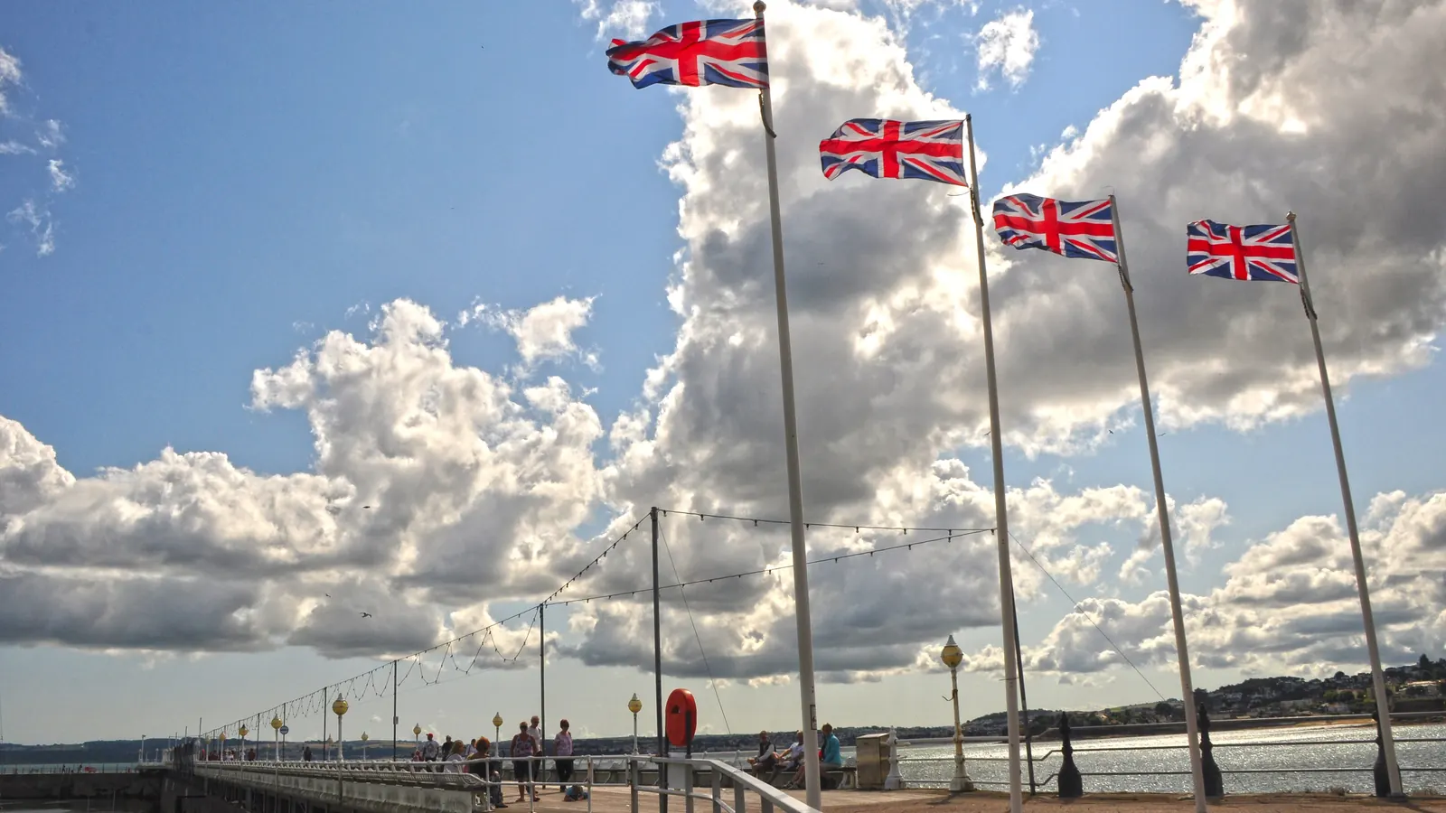 A row of flagpoles with Union Flags on Princess Pier in Torquay