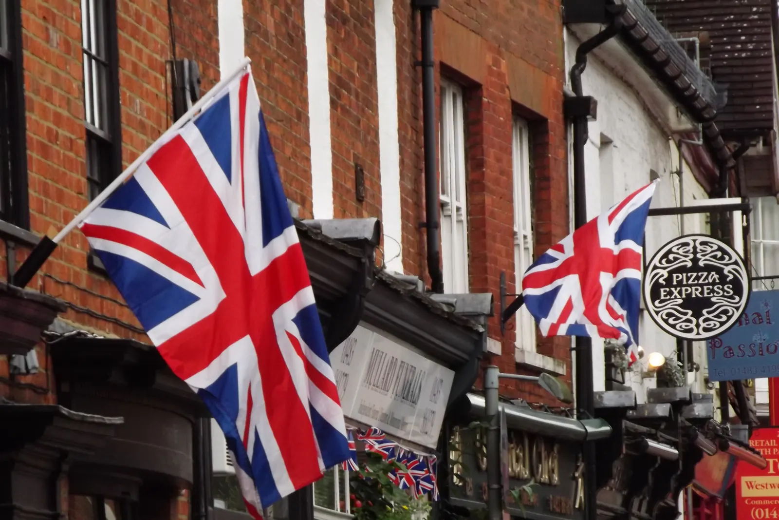 Union Flags on wall-mounted poles on a pub in Godalming