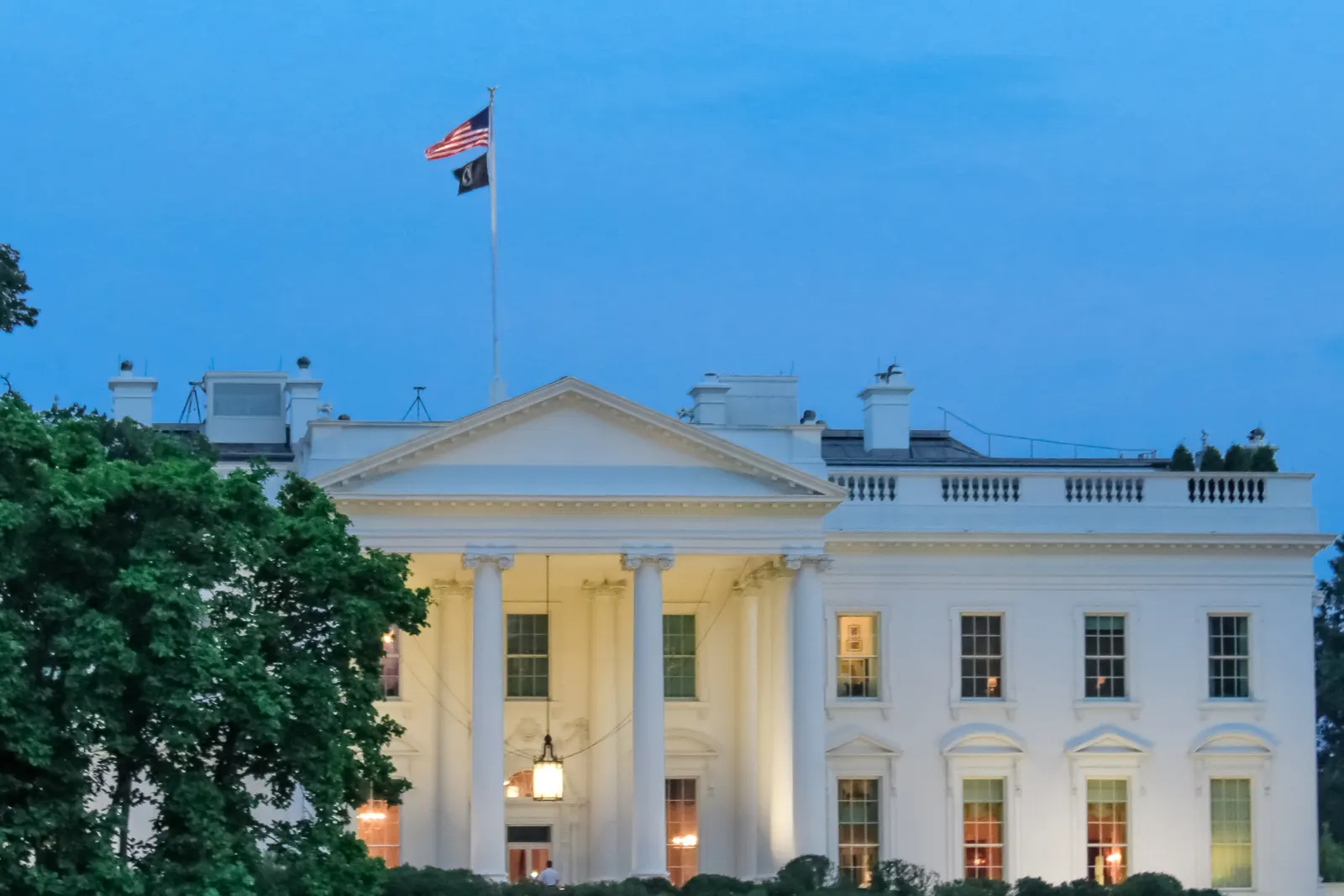 The White House with the flag of the United States on the roof in the evening light