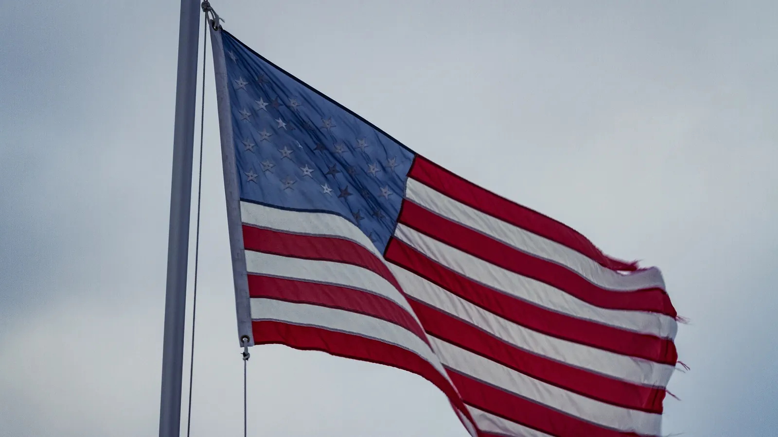 A worn flag of the United States flying in the wind in Lansing, Iowa