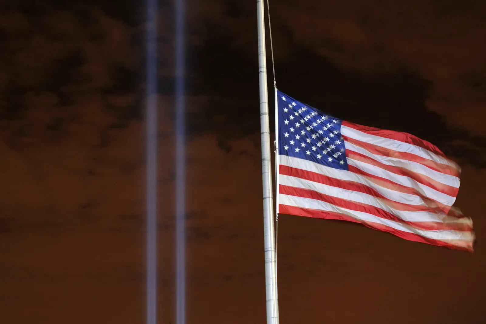 The flag of the United States at half-staff in front of the Tribute in Light on September 11