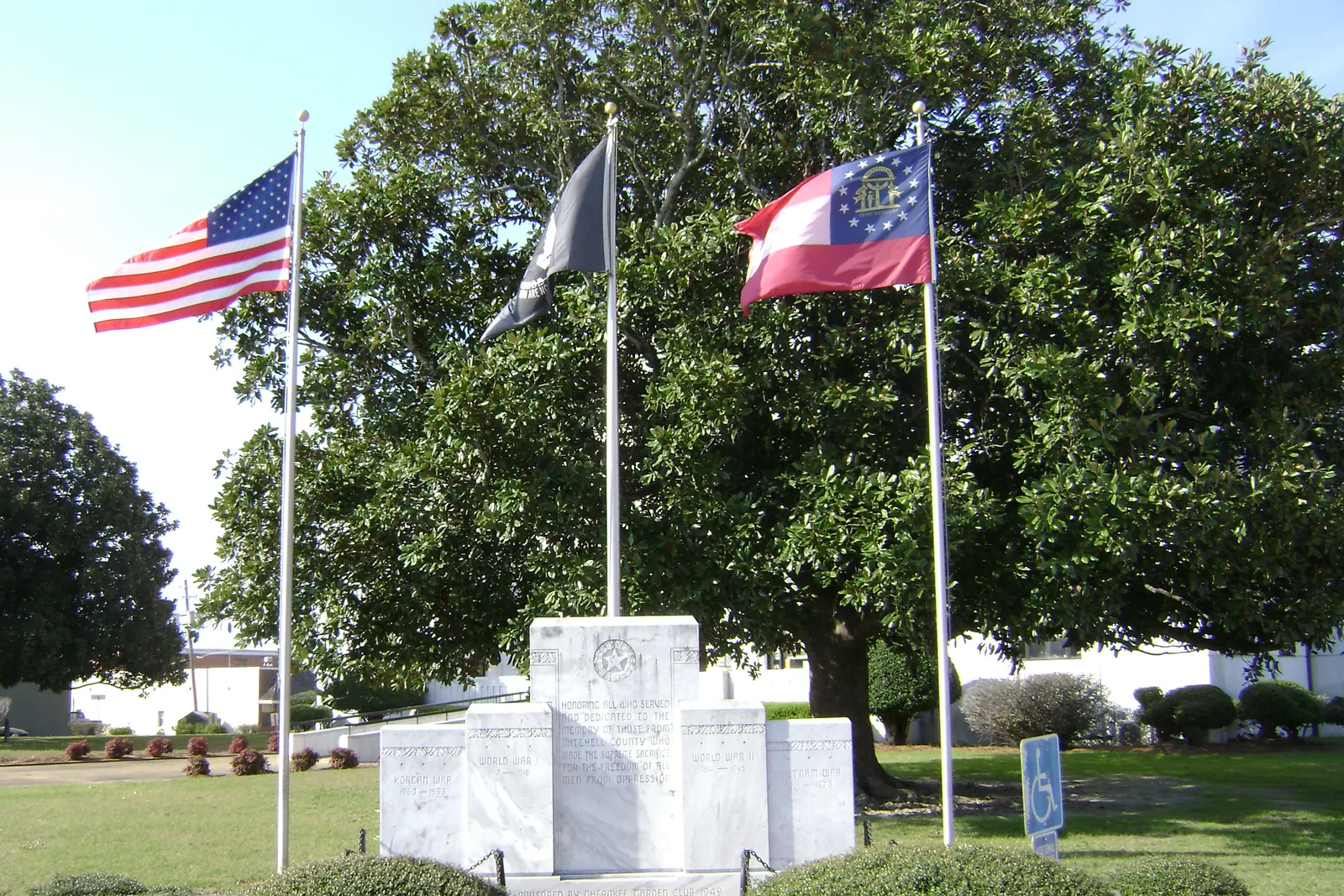 The flag of the United States, the POW/MIA flag and the flag of Georgia on three flagpoles at the war memorial in front of the Mitchell County Courthouse in Camilla, Georgia