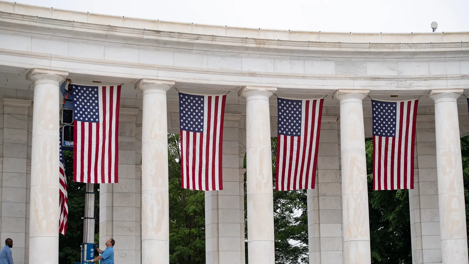 Flags of the United States hung between the columns of the Memorial Amphitheater at Arlington before Memorial Day 2024