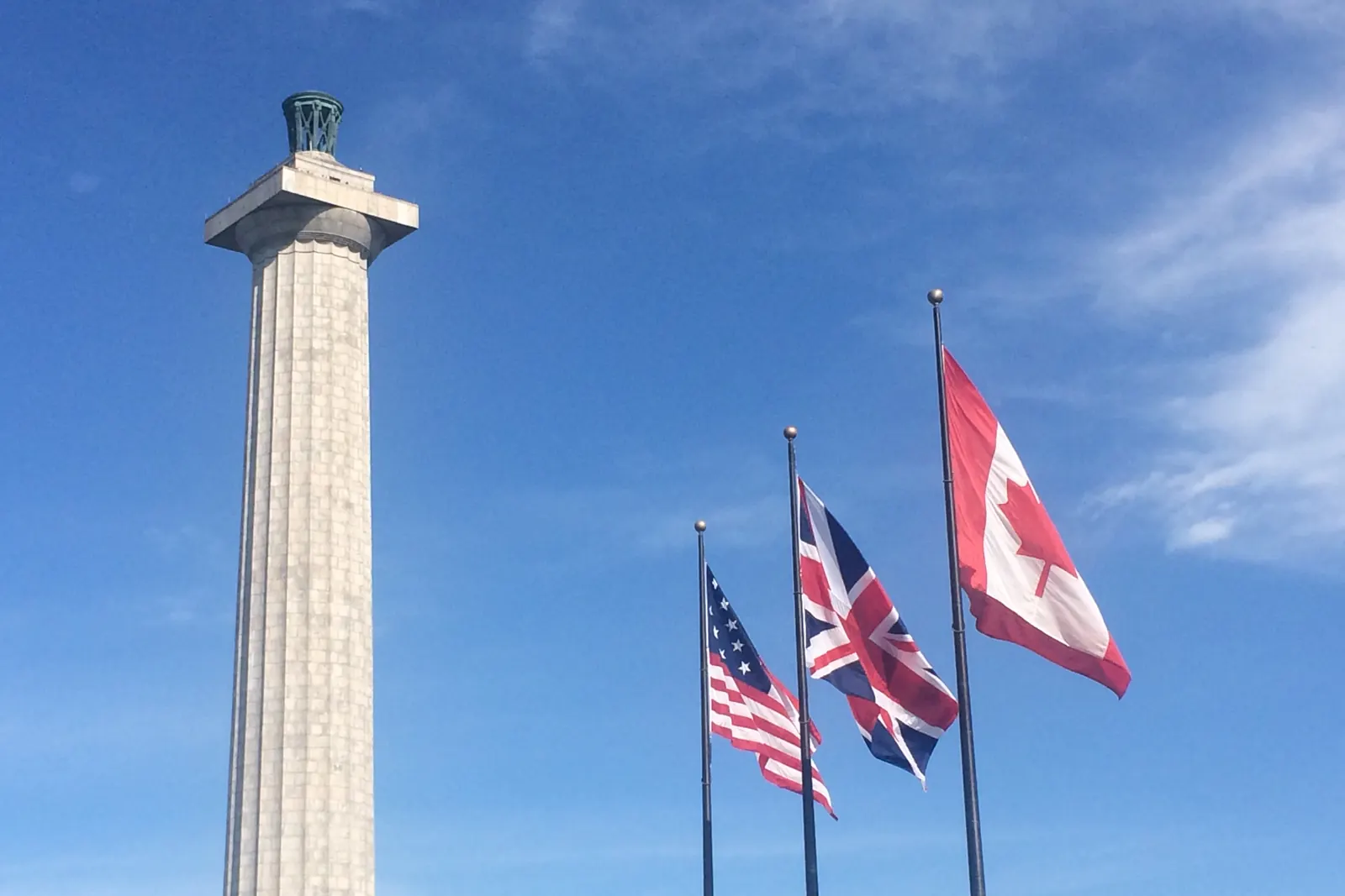 The flags of Canada, the United Kingdom and the United States on separate flagpoles at Perry’s Victory and International Peace Memorial