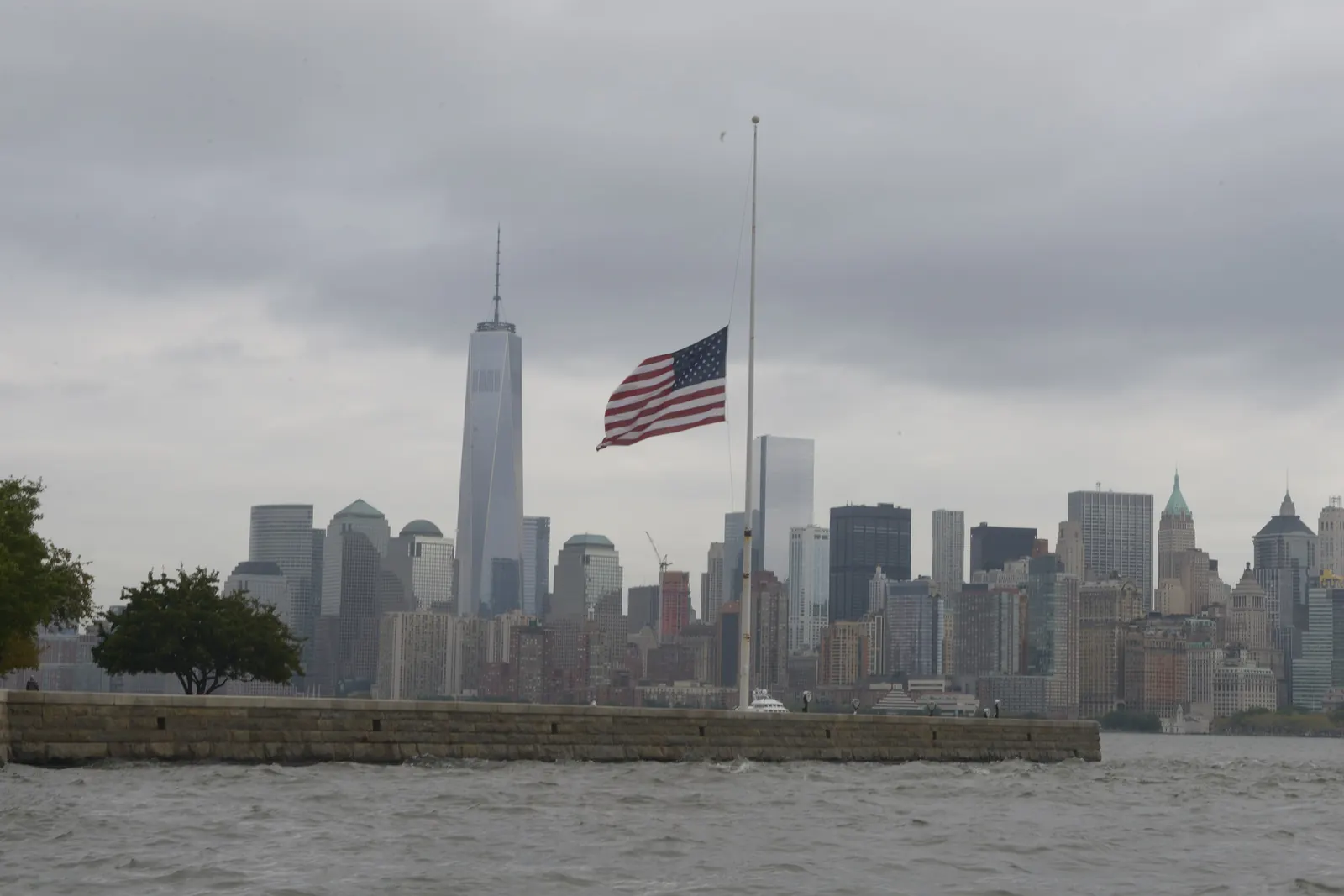 The flag of the United States at half-staff on Ellis Island with Lower Manhattan behind it, September 11, 2014