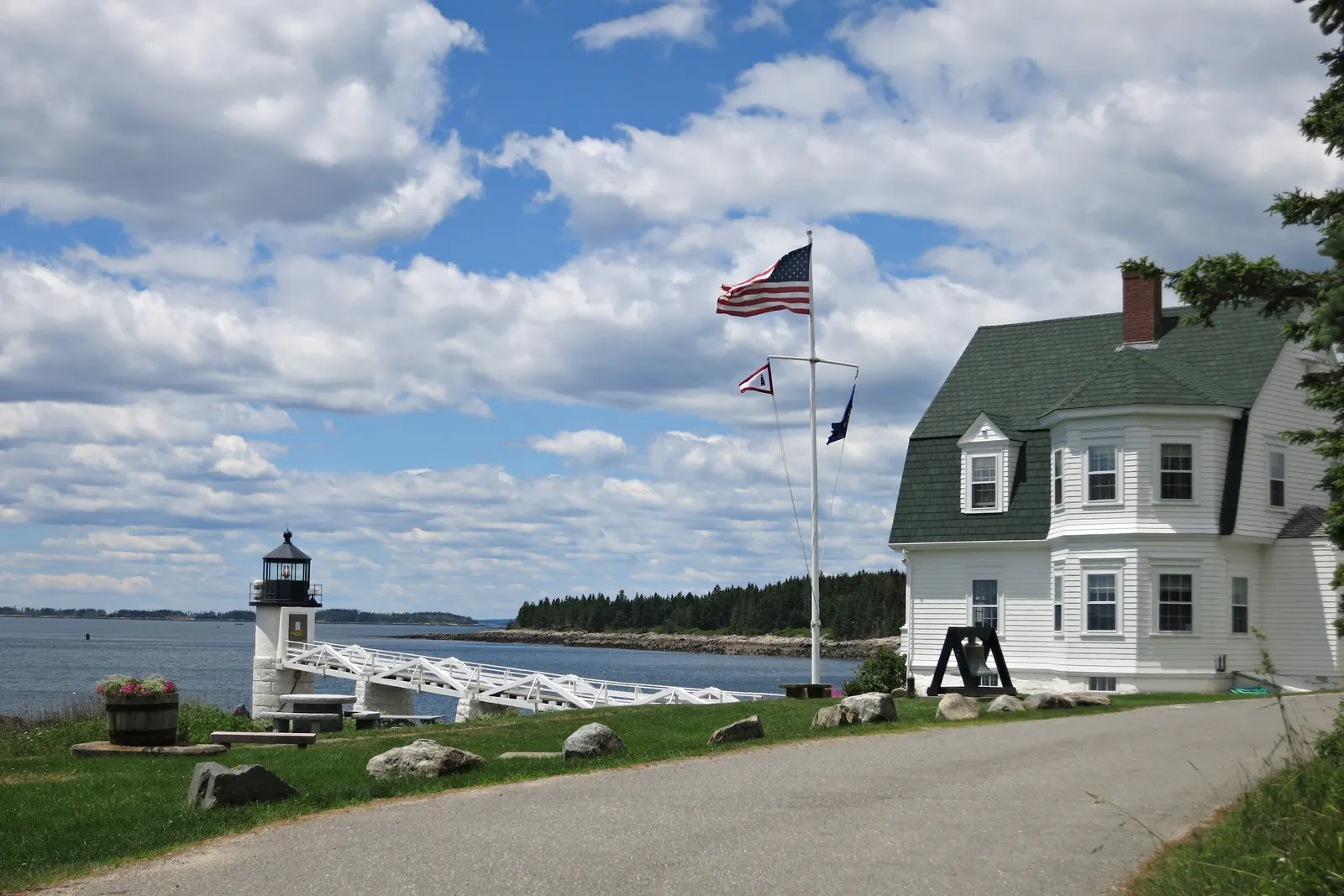 A flagpole with a yardarm by the Marshall Point Lighthouse in Maine